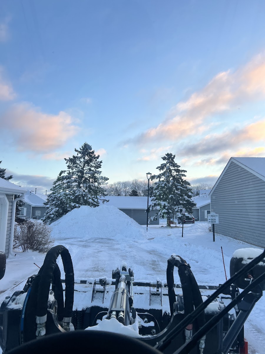 A Quintanilla snow plow clearing a snowy Minnesota street